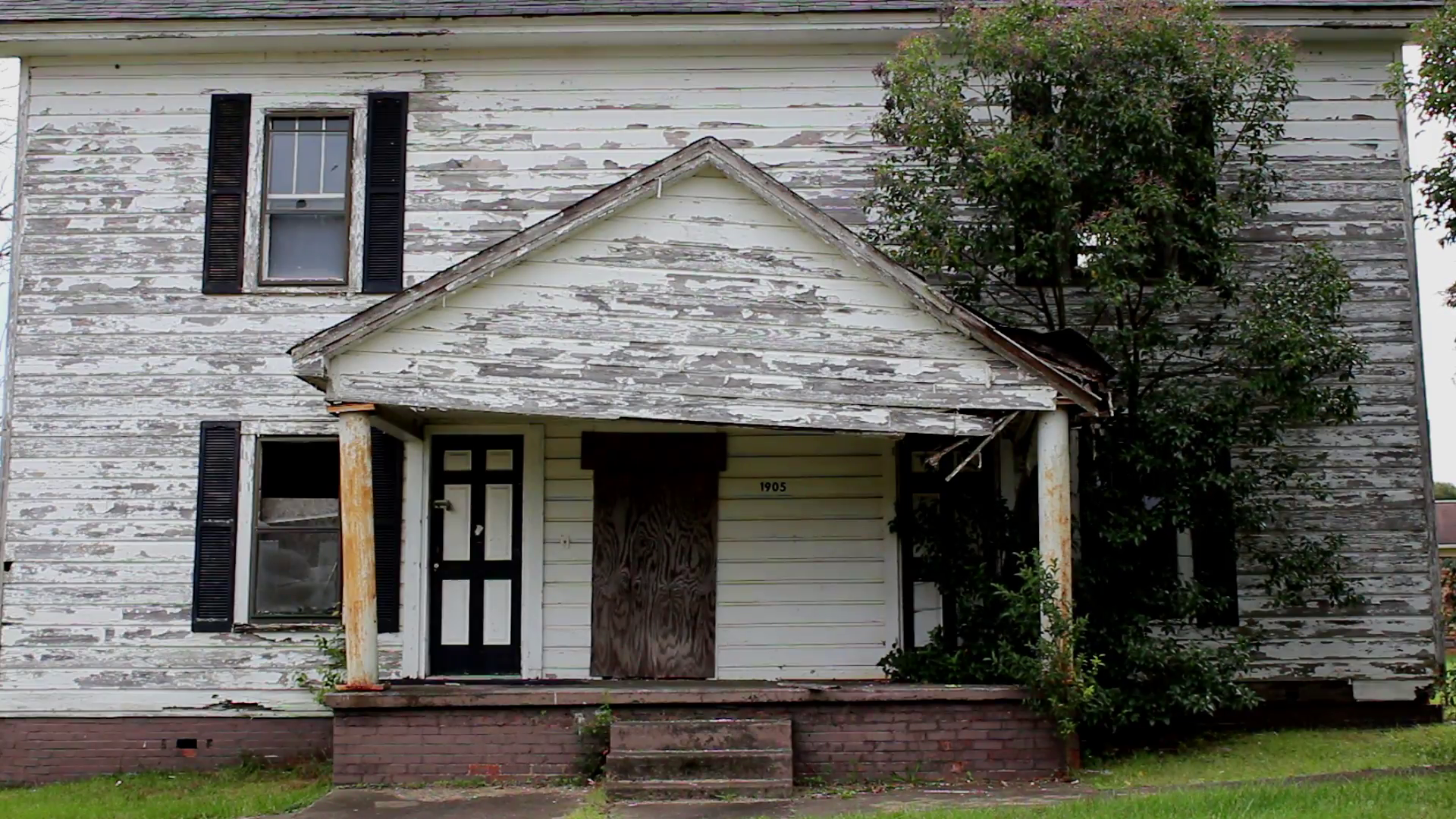 an abandoned creepy house with broken windows and peeling paint 
